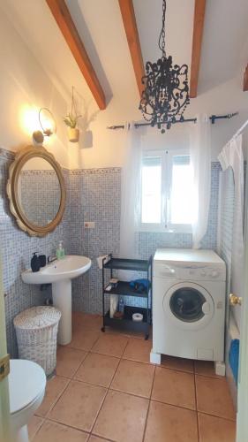 a bathroom with a washing machine and a sink at Casa Verde Oliva in Sedella