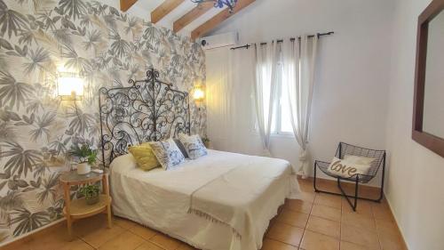 a bedroom with a bed with a floral wall at Casa Verde Oliva in Sedella