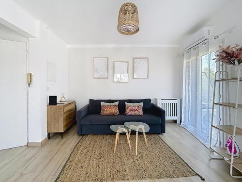 un salon avec un canapé bleu et une table dans l'établissement Studio Hippodrome, à Cagnes-sur-Mer