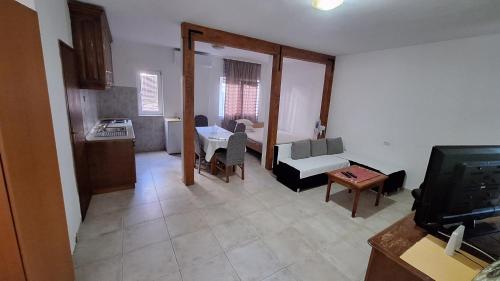 a living room with a kitchen and a room with a tv at Ivanovic Family House Apartments in Sutomore