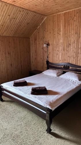 a bed in a wooden room with two pillows on it at Шервуд in Myta