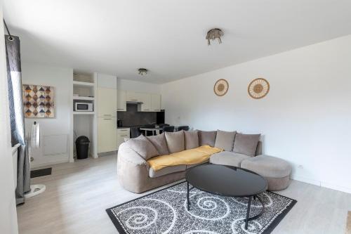 a living room with a couch and a table at Maisonnette 2 Un Séjour à Part in Longeville-lès-Metz