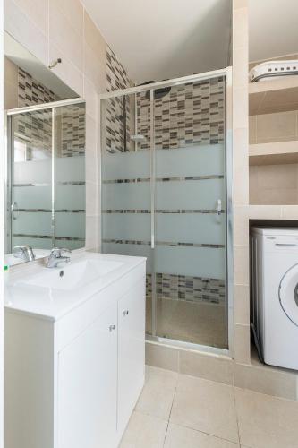 a bathroom with a sink and a washing machine at Maisonnette 2 Un Séjour à Part in Longeville-lès-Metz