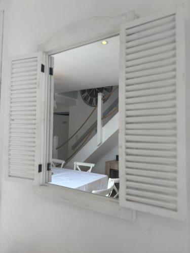 a window in a white room with a staircase at La villa Ty Mor Braz in Plouarzel