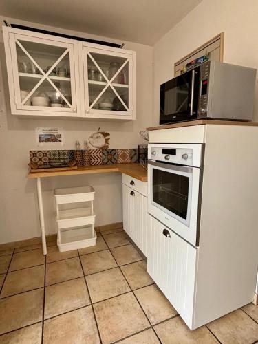 a kitchen with a microwave and a stove at La villa Ty Mor Braz in Plouarzel