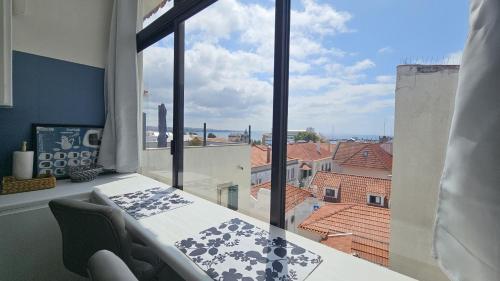a room with a table and a large window at Historic center apartment Cascais in Cascais