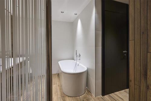 a bathroom with a white sink and a black door at Radisson Blu Hotel, Bergamo ChorusLife in Bergamo