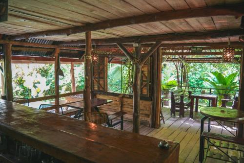 a restaurant with a bar and tables and chairs at Bamboo River Lodge in Horquetas