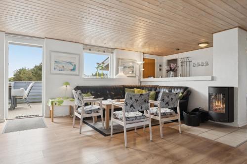 a living room with a table and chairs and a fireplace at Energy-Efficient Pool House Located Between The Sea And The Fjord in Ringkøbing