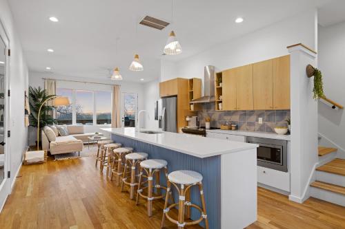 a kitchen with a large island with bar stools at Coachella -An Atomic Ridge Home in Chattanooga