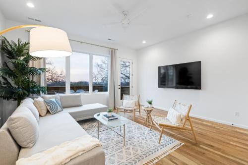 a living room with a couch and a tv at Coachella -An Atomic Ridge Home in Chattanooga