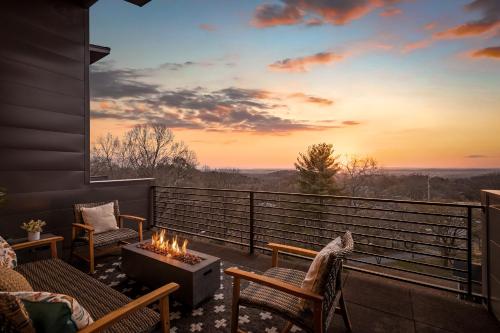 a balcony with a fire pit and chairs and a sunset at Coachella -An Atomic Ridge Home in Chattanooga