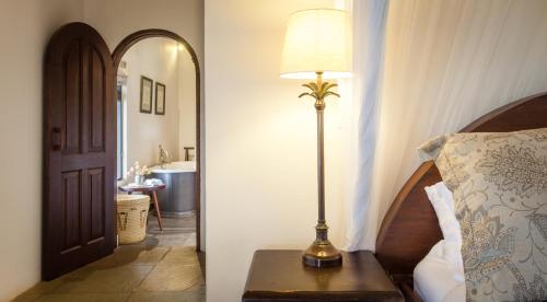 a lamp sitting on a table next to a bedroom at Ololo Safari Lodge & Farm in Nairobi