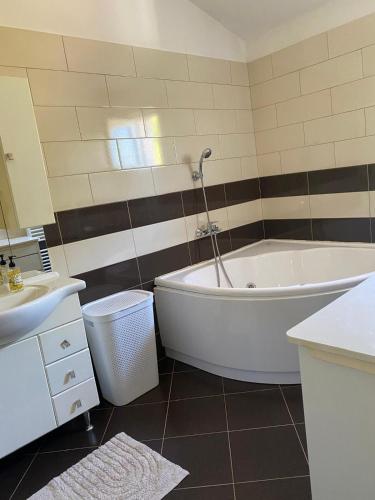 a bathroom with a white tub and a sink at Apartman Toni in Bibinje