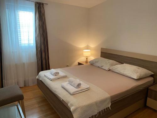a bedroom with a bed with towels on it at Apartman Toni in Bibinje