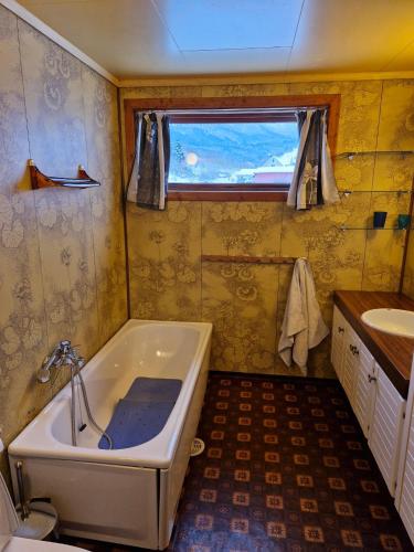 a small bathroom with a tub and a sink at Stall Rygg Apartment, Gloppen 
