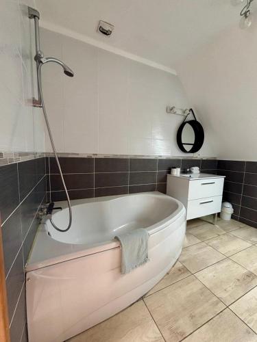 a bath tub in a bathroom with a shower at La villa Ty Mor Braz in Plouarzel