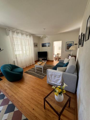 a living room with a couch and a table at Maison à Lourdes, avec jardin in Lourdes