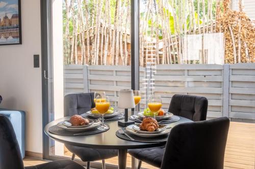a table with food and glasses of orange juice at Escapade balnéo, terrasse, parking, plage in Arès