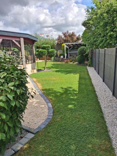 a garden with a stone walkway next to a fence at Villa Rosso in Clisson