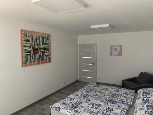 a bedroom with two beds and a painting on the wall at Chalupa U Studny in Jaroslavice