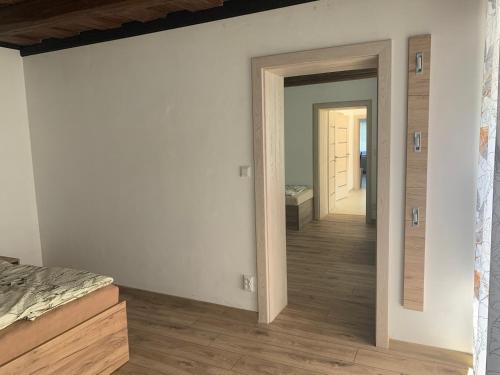 a bedroom with a door open to a hallway at Chalupa U Studny in Jaroslavice