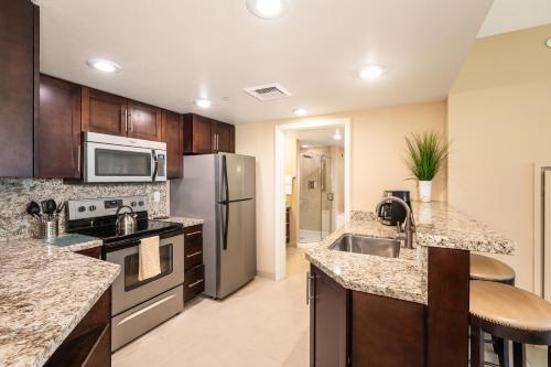 a kitchen with stainless steel appliances and granite counter tops at The Berkley, Las Vegas in Las Vegas