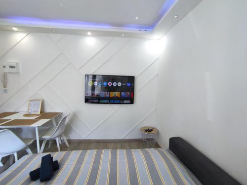 a room with a bed and a table and a television at CinéLux - Appartement entier - Parking gratuit in Algrange