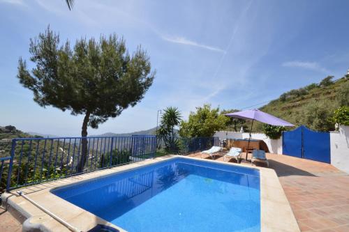 a swimming pool with a fence and a tree at Casa Carámbila in Cómpeta