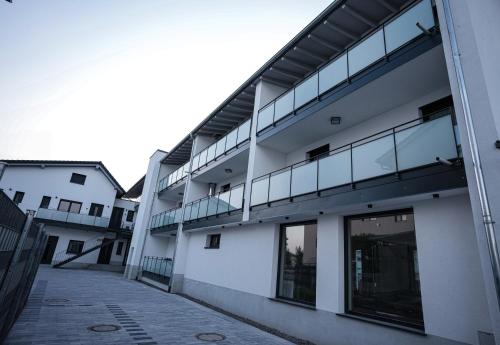 an external view of a white building with glass windows at Be Grand Apartments Rust in Rust