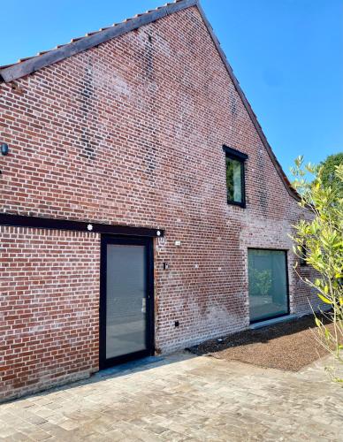 a brick building with two garage doors on it at Hoeve DeKleinheide 1 in Dessel