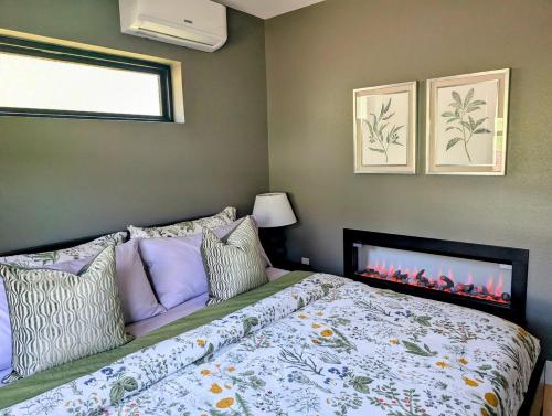 a bedroom with a bed with a fire place at Howells Nest - Cozy 2 Bed - King Bedroom and Sleeping Loft Escape! in Waynesville