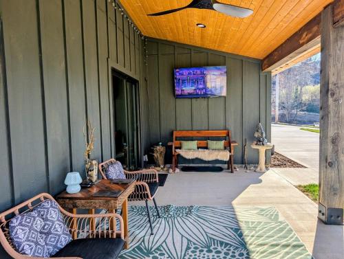 a screened in porch with a tv on the wall at Howells Nest - Cozy 2 Bed - King Bedroom and Sleeping Loft Escape! in Waynesville