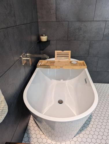 a bath tub with a wooden tray on top of it at Howells Nest - Cozy 2 Bed - King Bedroom and Sleeping Loft Escape! in Waynesville