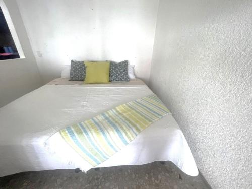 a white bed with two pillows on top of it at Suite para 4 personas in Acapulco