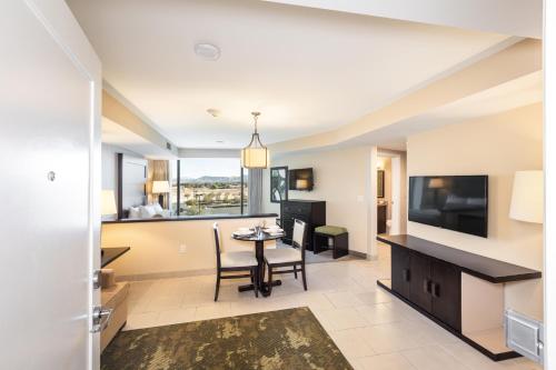 a living room with a dining room table and a television at The Berkley, Las Vegas in Las Vegas