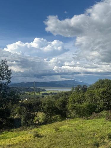 a view of a field with trees and a sky at Altos del paraíso in Fúquene