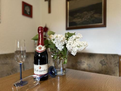 a bottle of wine and a vase of flowers on a table at Haus Anna in Stadlern