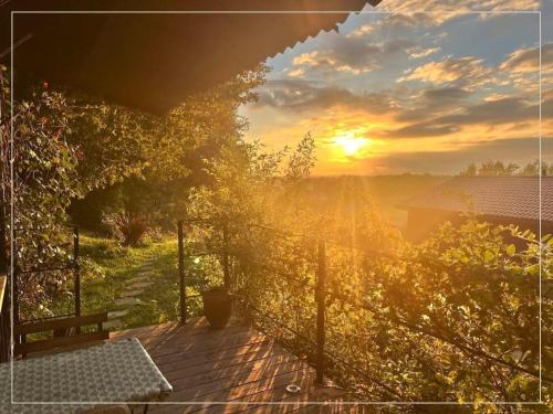 a view of a sunset from a wooden deck at La Pause En Soi in Ponlat-Taillebourg