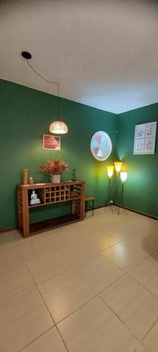 a room with a green wall with two lights and a table at Pousada das Flores in Conservatória