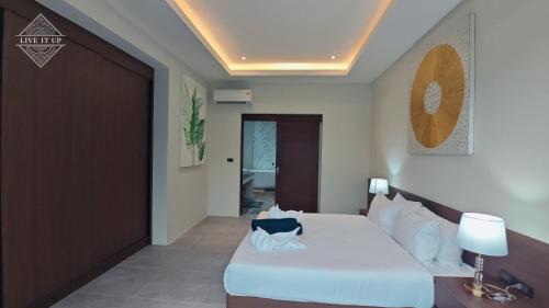 a bedroom with a white bed and a brown door at Santi Tara Villas in Amphoe Koh Samui