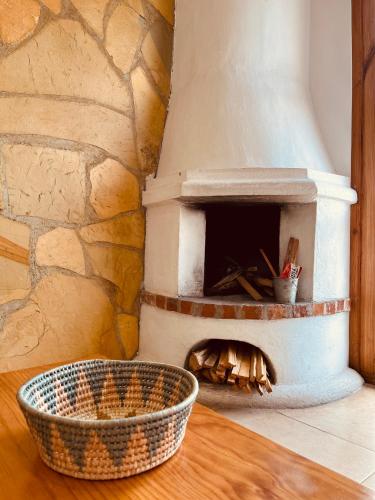 a stone oven with a wooden table and a basket at Gaia Guest House in San Cristóbal de Las Casas