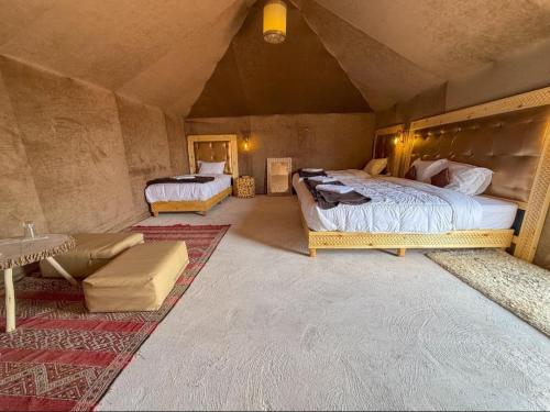a bedroom with two beds and a couch in a room at fabulousluxurycamp in Merzouga