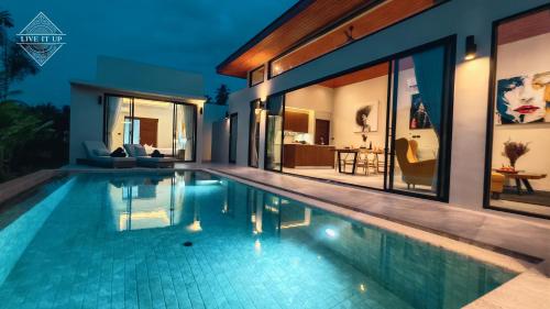 a swimming pool in a villa at night at Santi Tara Villas in Amphoe Koh Samui