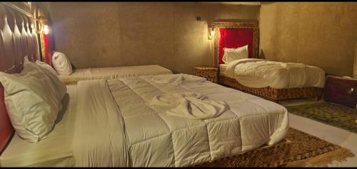 a hotel room with two beds and a mirror at fabulousluxurycamp in Merzouga