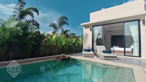 a villa with a swimming pool and a bedroom at Santi Tara Villas in Amphoe Koh Samui