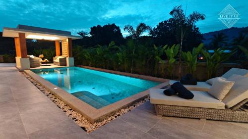 a swimming pool in a backyard at night at Santi Tara Villas in Amphoe Koh Samui