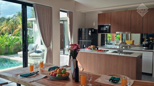 a kitchen with a table with a bowl of fruit at Santi Tara Villas in Amphoe Koh Samui