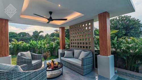 a patio with two chairs and a ceiling fan at Santi Tara Villas in Amphoe Koh Samui