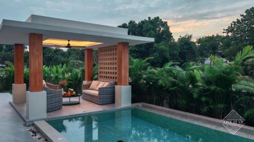 a backyard with a swimming pool and a gazebo at Santi Tara Villas in Amphoe Koh Samui